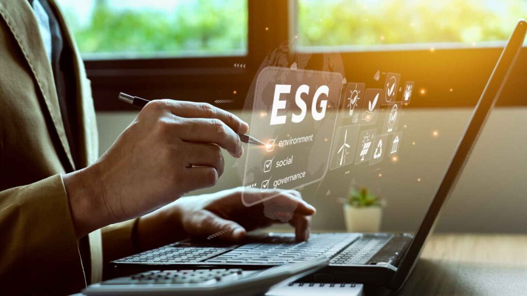 Pessoa em ambiente corporativo interagindo com interface virtual de ESG (ambiental, social e governança) em um notebook.