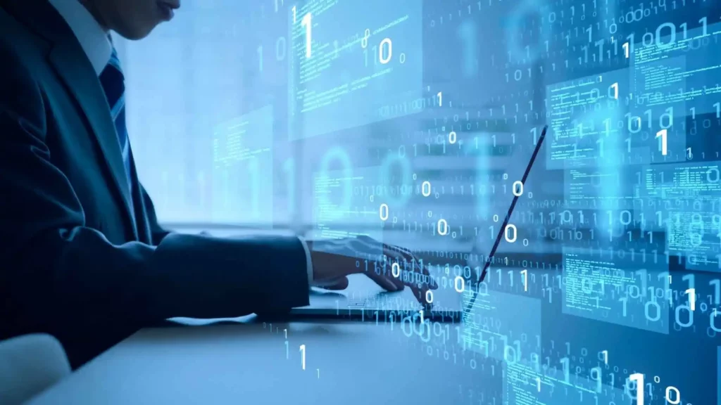 Profissional de tecnologia digitando em um notebook, com códigos binários e linhas de programação projetadas sobre a imagem.