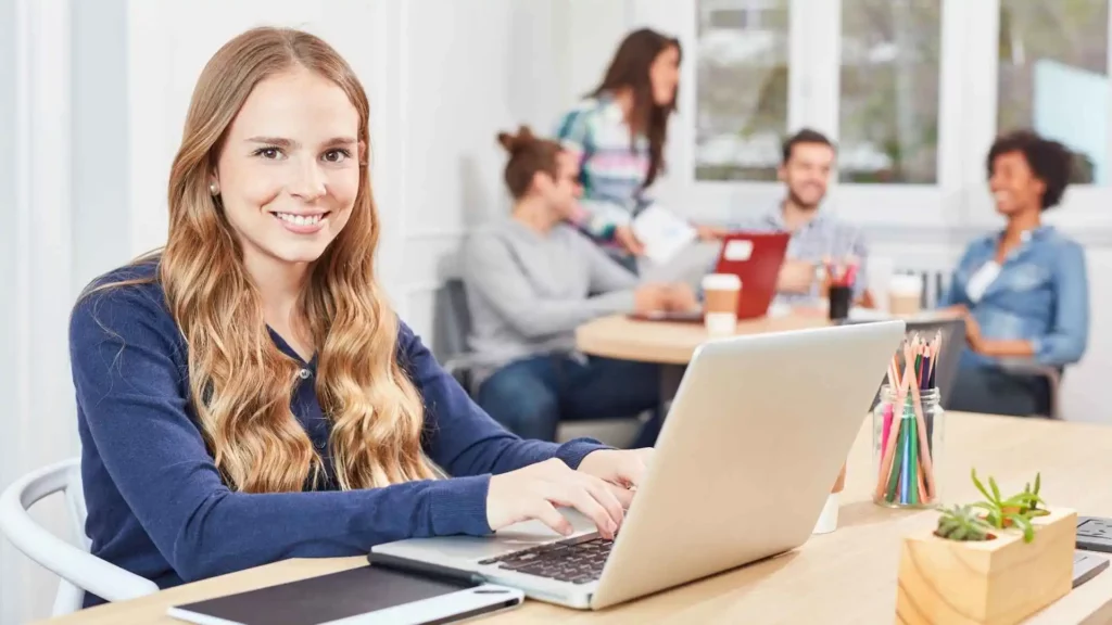 Profissional em início de carreira em tecnologia participando de um programa de trainee tech, estudando em ambiente colaborativo