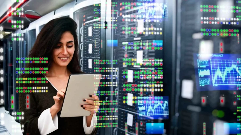 Profissional de engenharia de dados utilizando tablet em data center, monitorando servidores e performance de sistemas