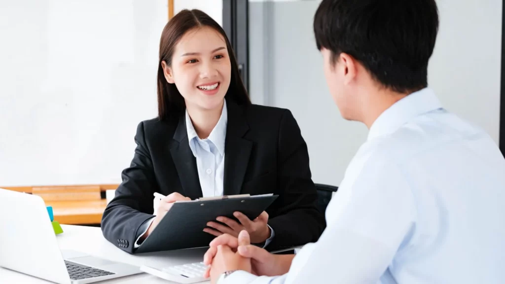 Recrutadora conduzindo entrevista técnica de TI com candidato em ambiente corporativo